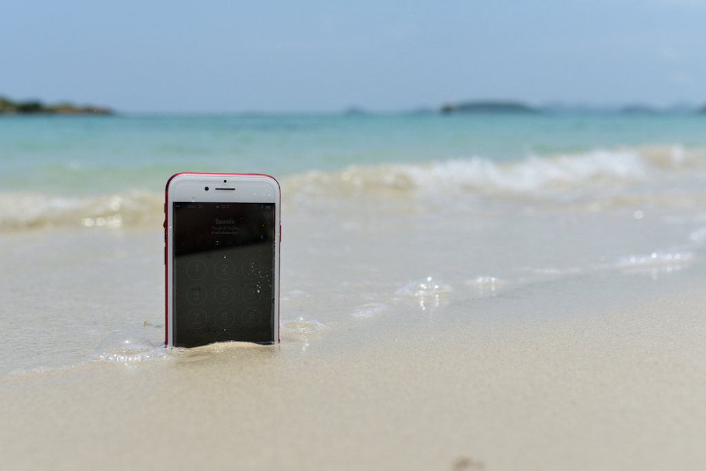 phone in sand and water at beach