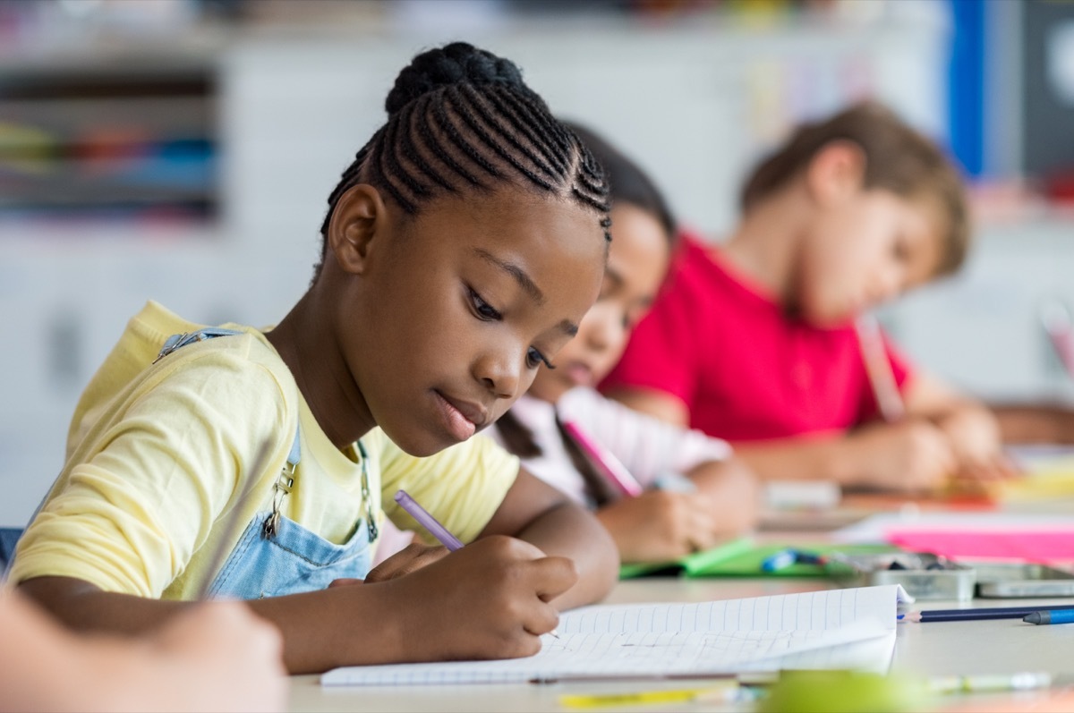 young students writing at desks in school