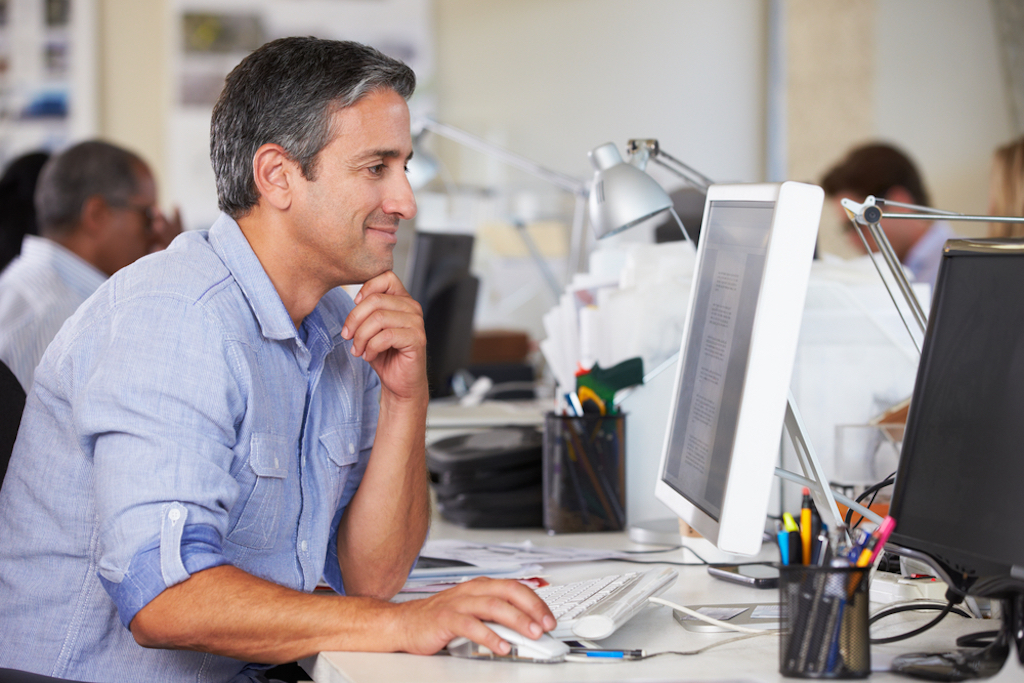 happy middle-aged man working in office