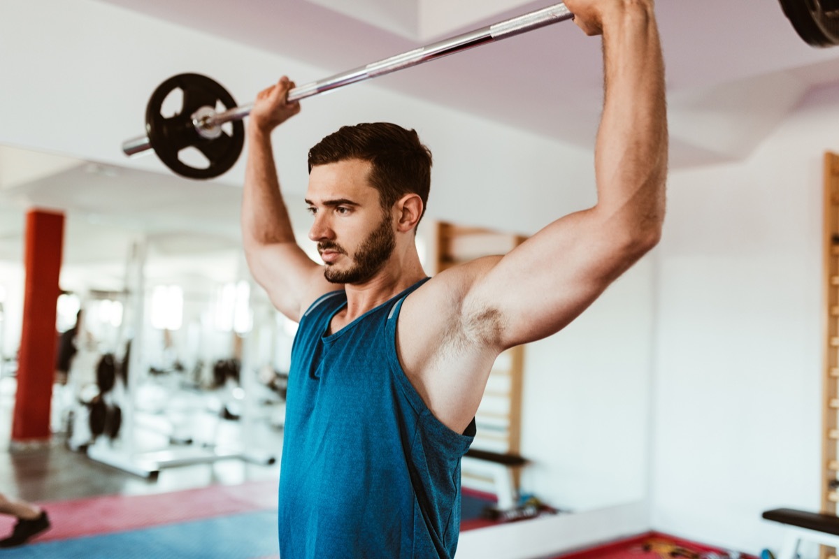 man using the barbell at gym