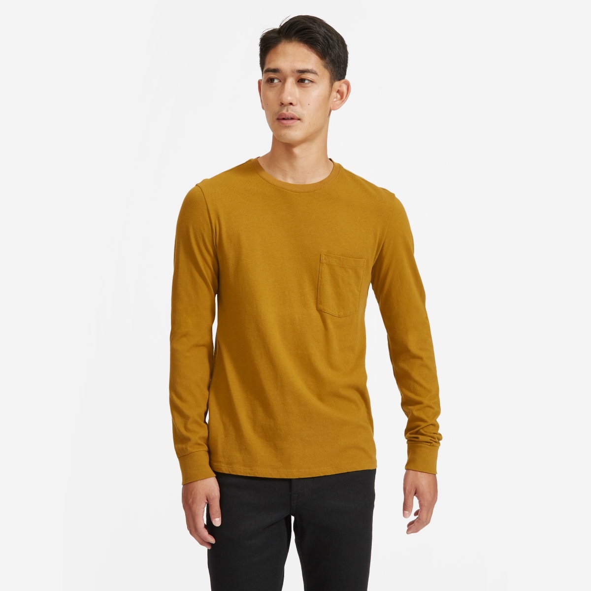 young asian man in yellow long sleeved tee and black pants