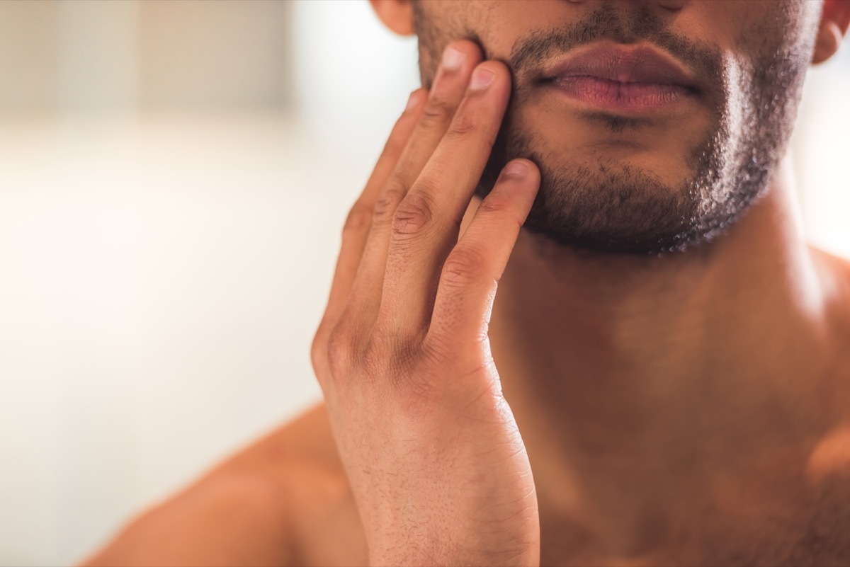 closeup of man touching face