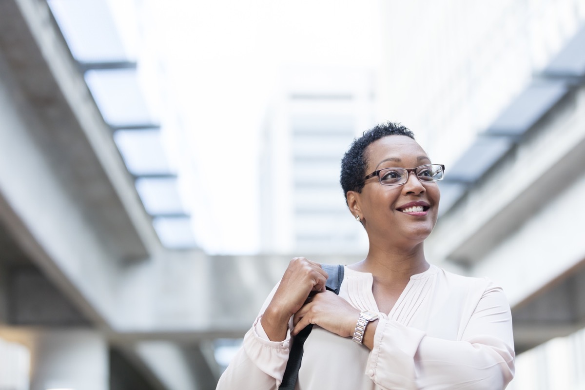 middle aged black woman walking and smiling