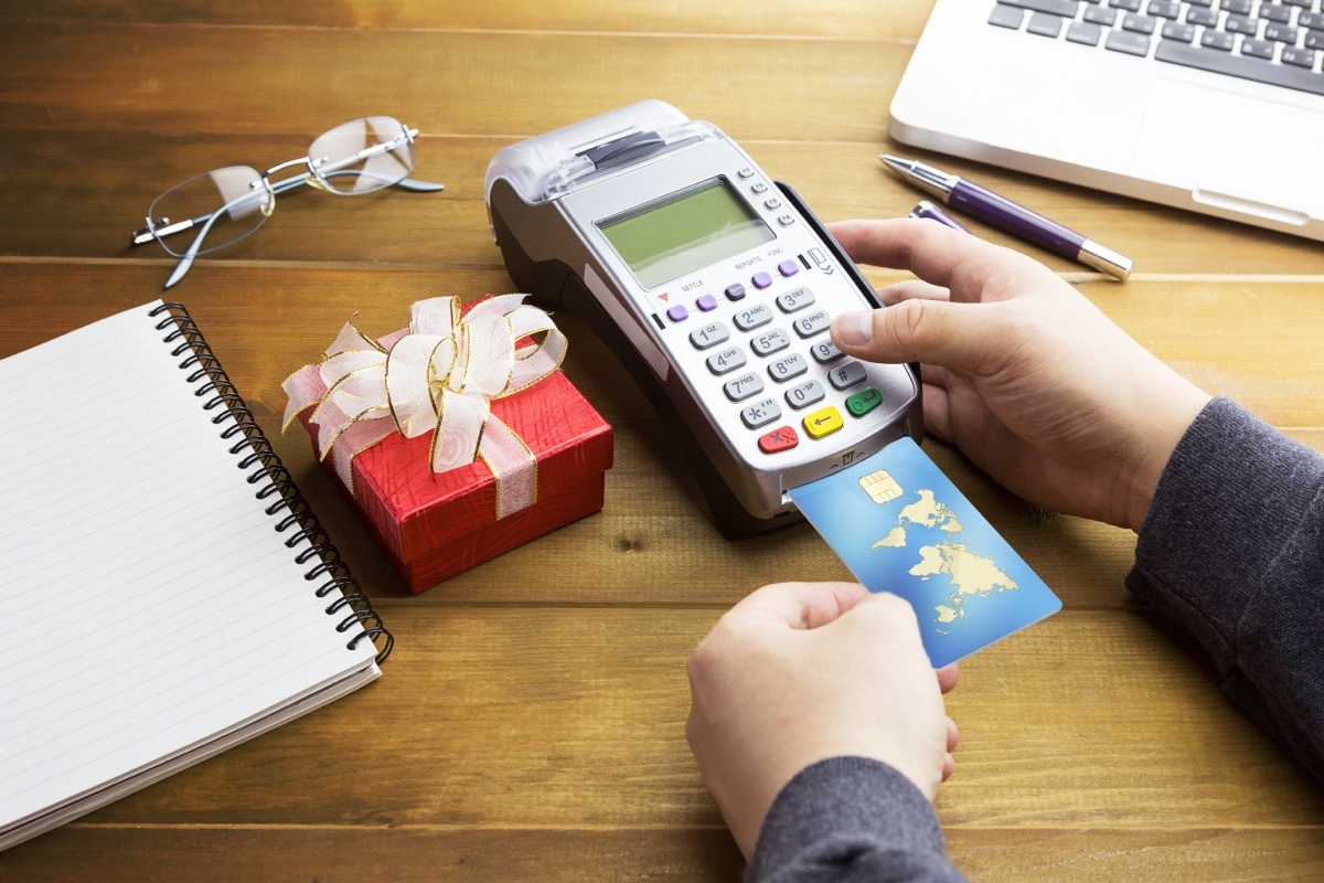 Credit card in a machine with a red gift box