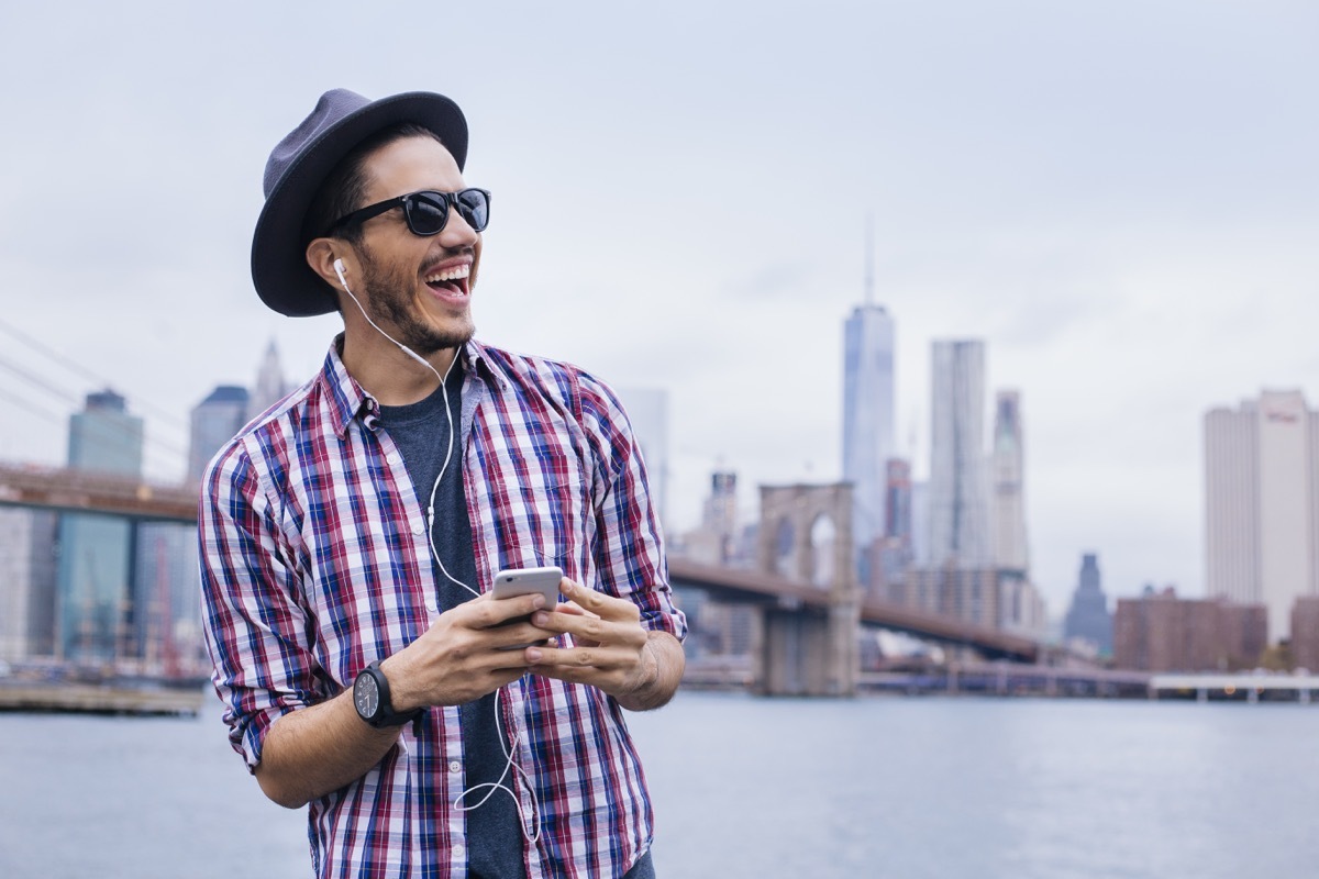 Happy man listening to music outside in earphones