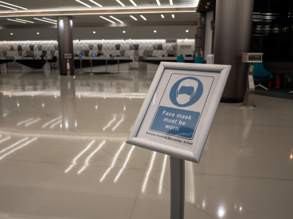 Sign in an empty hotel lobby requiring everyone who enters to wear a face mask during coronavirus lockdown