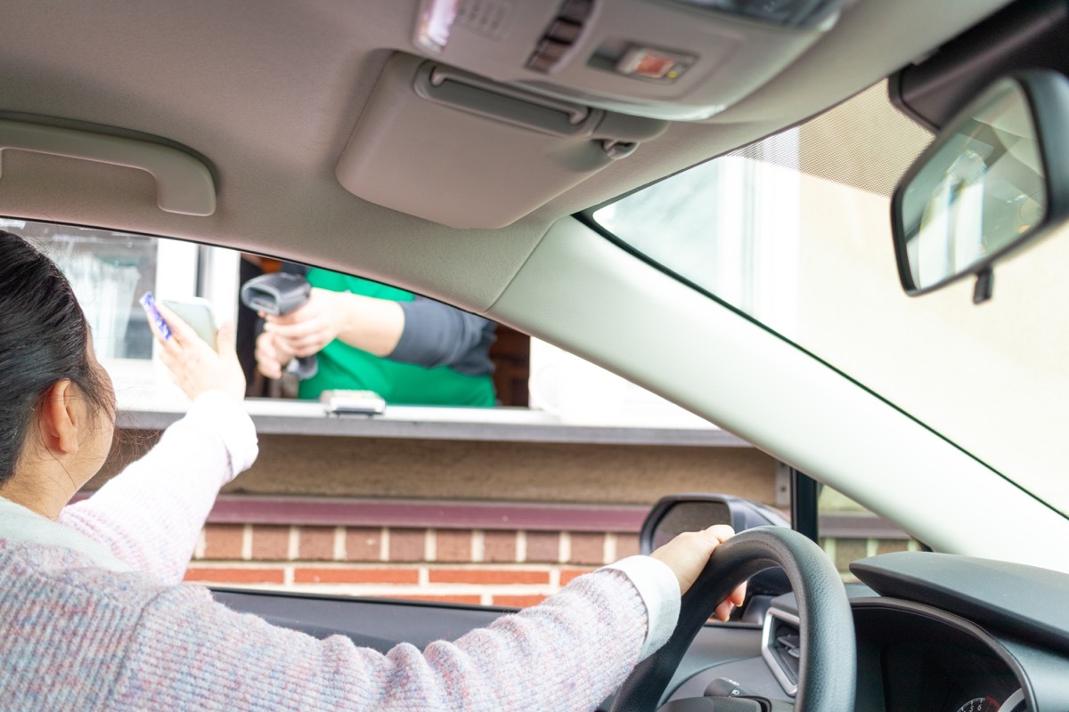 Young woman pays for service through Drive thru