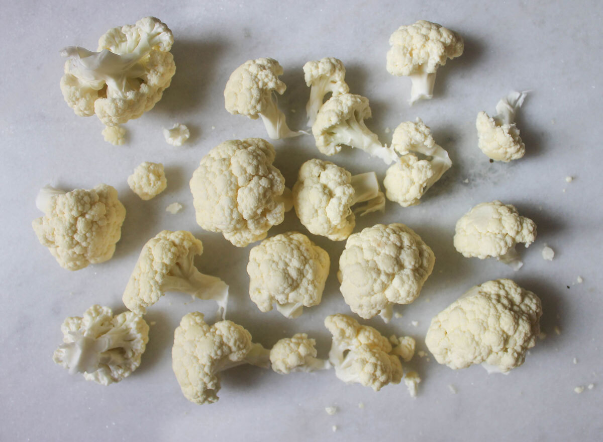 large cauliflower florets on a marble counter top