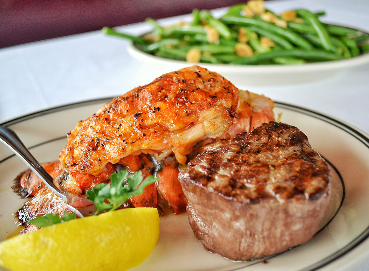 steak with lobster tail and lemon wedge