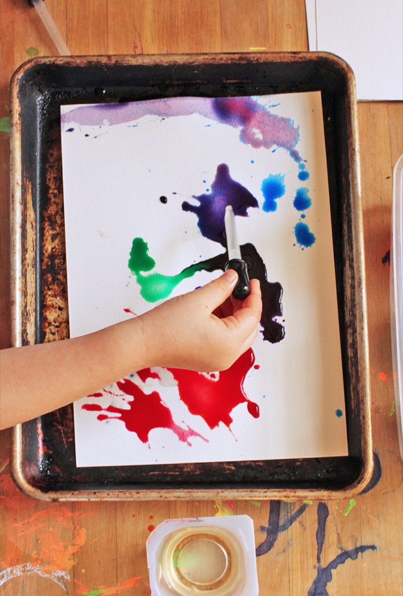 kid dropping paint on paper with eye dropper