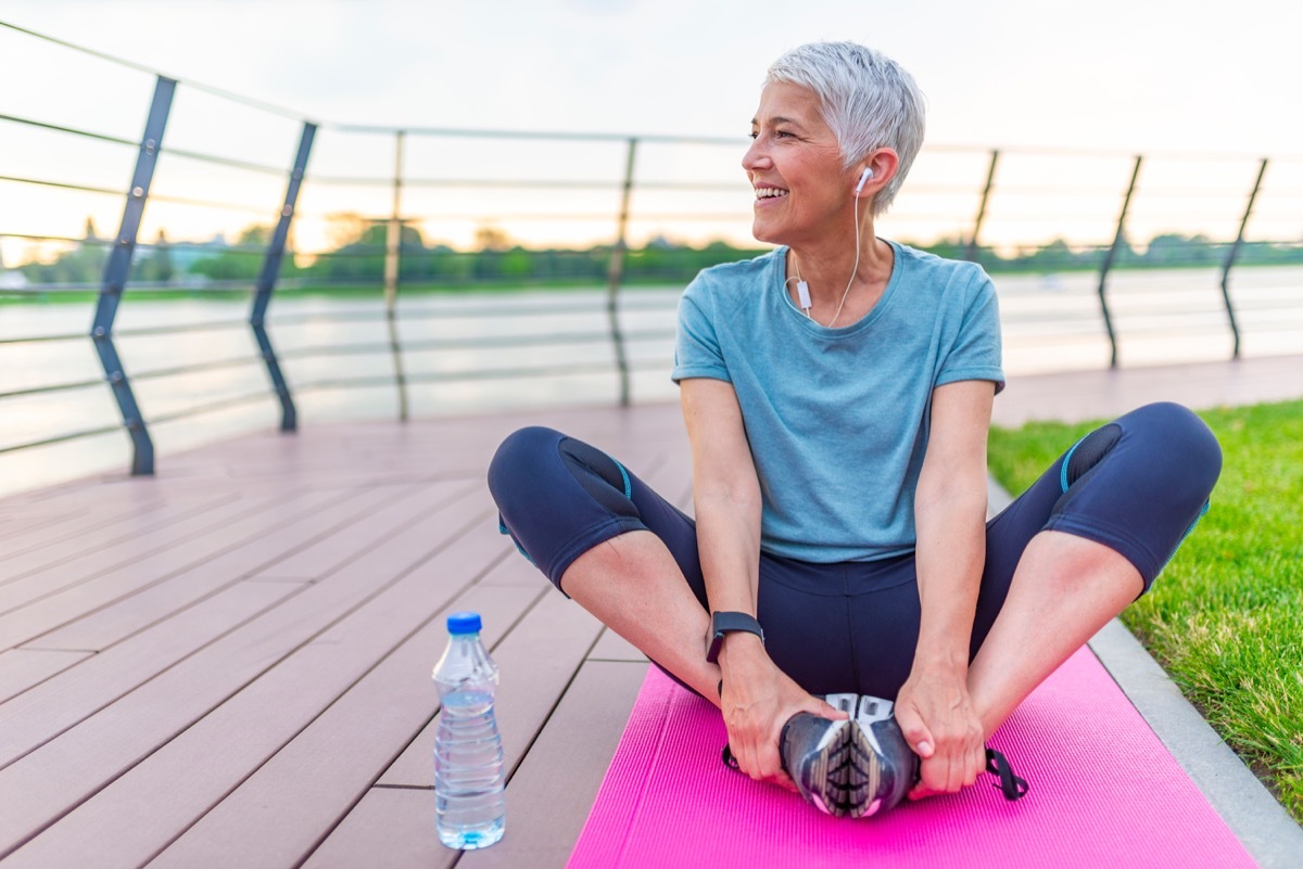 Older woman stretching on mat