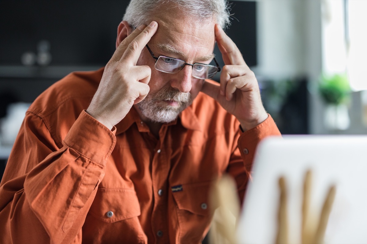 Mature businessman reading a problematic e-mail on laptop.