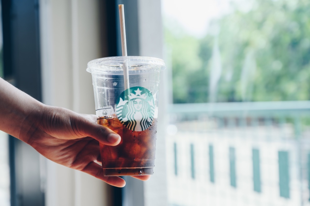 Chiang Mai, Thailand : 22/07/2020 : Someone holding a cup of Cold Brew coffee in Starbucks coffee shop. Cold brewing is a method of brewing that combines ground coffee and cool water.