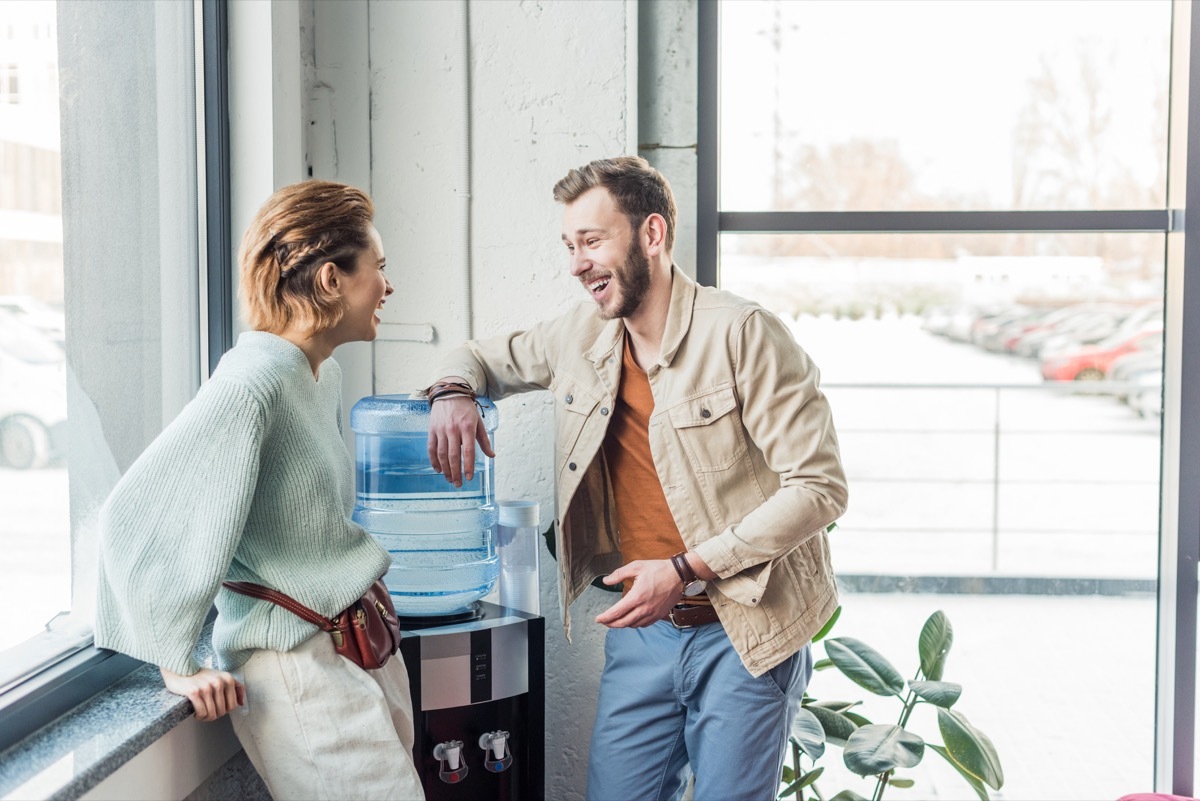 casual businessman and woman talking and laughing in loft office