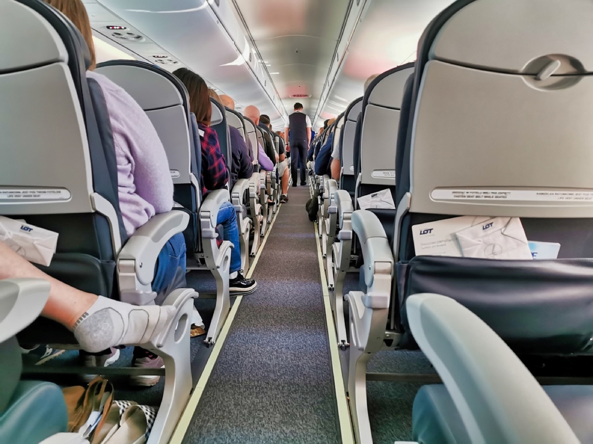 aisle of a plane with someone's feet in socks sticking out