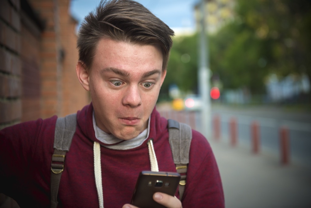 boy looking at a cell phone equipped with artificial intelligence