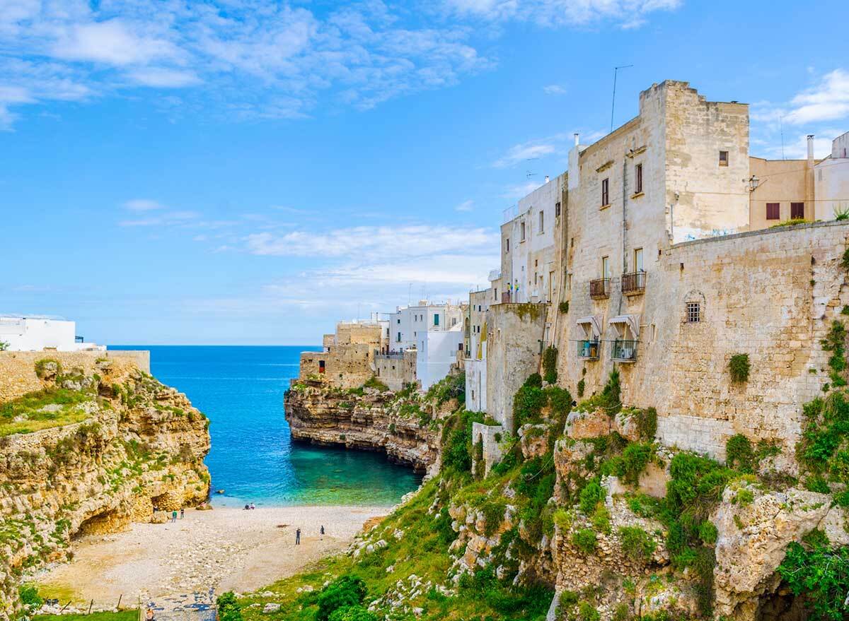 a cove of turquoise water with italian buildings on the side