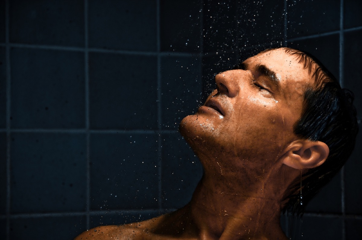 middle aged white man in shower with eyes closed