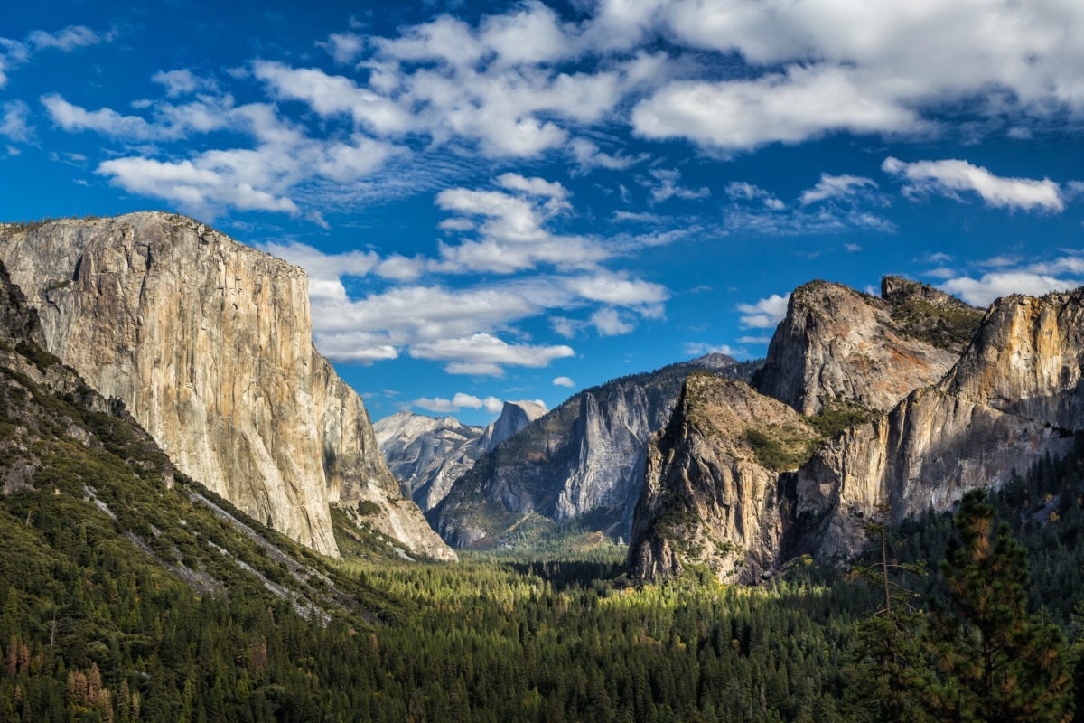 green valley with granite peaks and a blue sky landscape