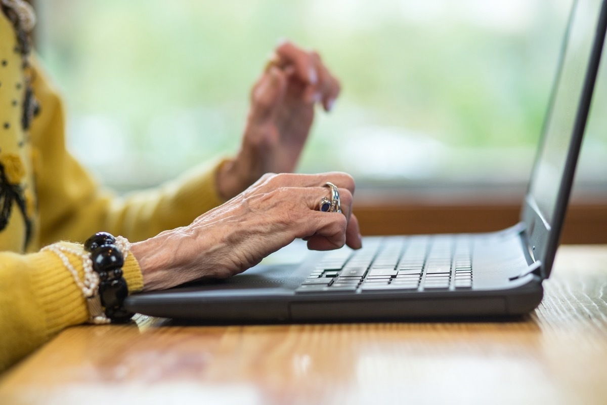 Laptop and senior woman's hands. Notebook pc on a desk