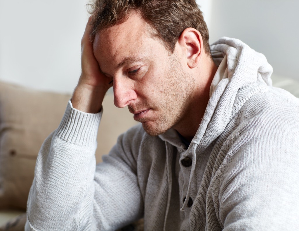 sad man holding his head, ways your body changes after 40