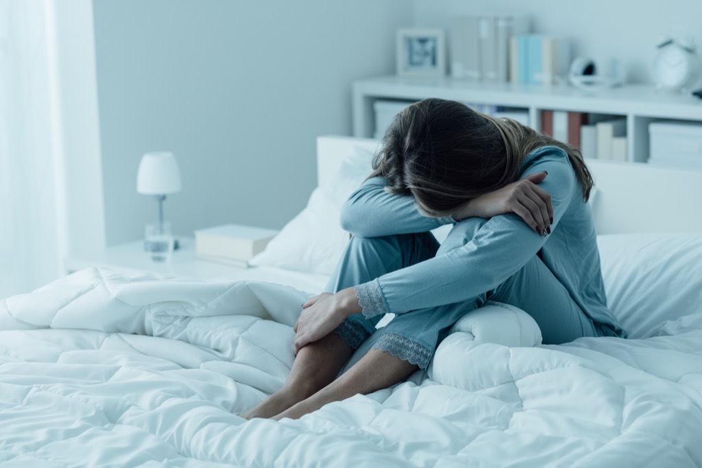 woman alone on bed sad