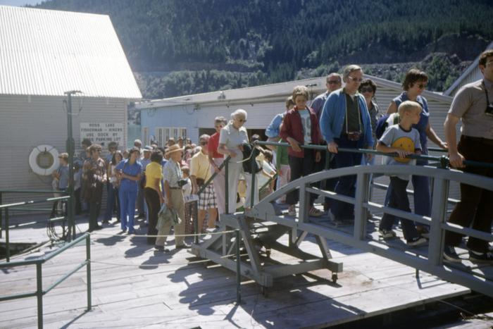 a group of people disembark off a boat