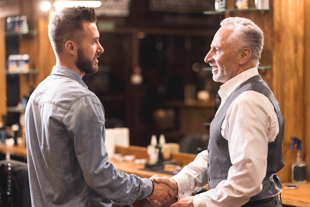 Man shaking barber's hand in his shop