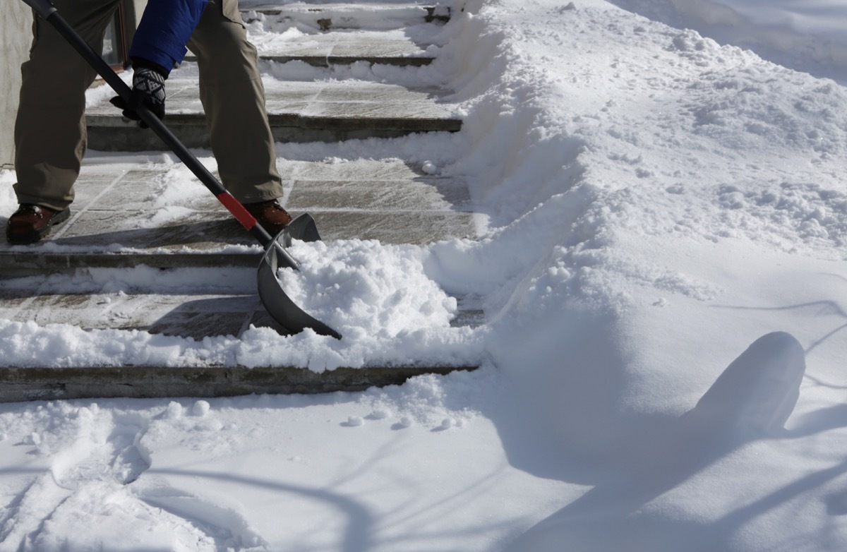 Man shoveling the show on bright winter day