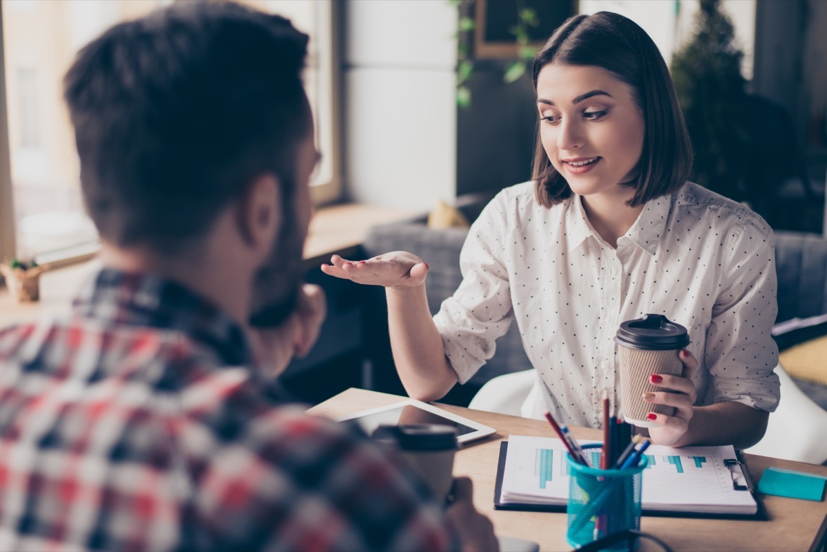 man and woman speaking at their desks