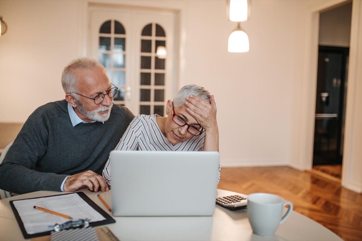 Mature couple calculating finances at home.