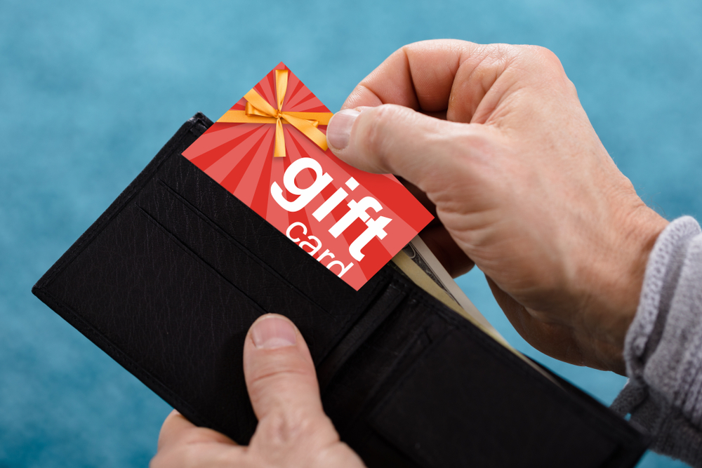 A closeup of a hand removing a gift card from a wallet