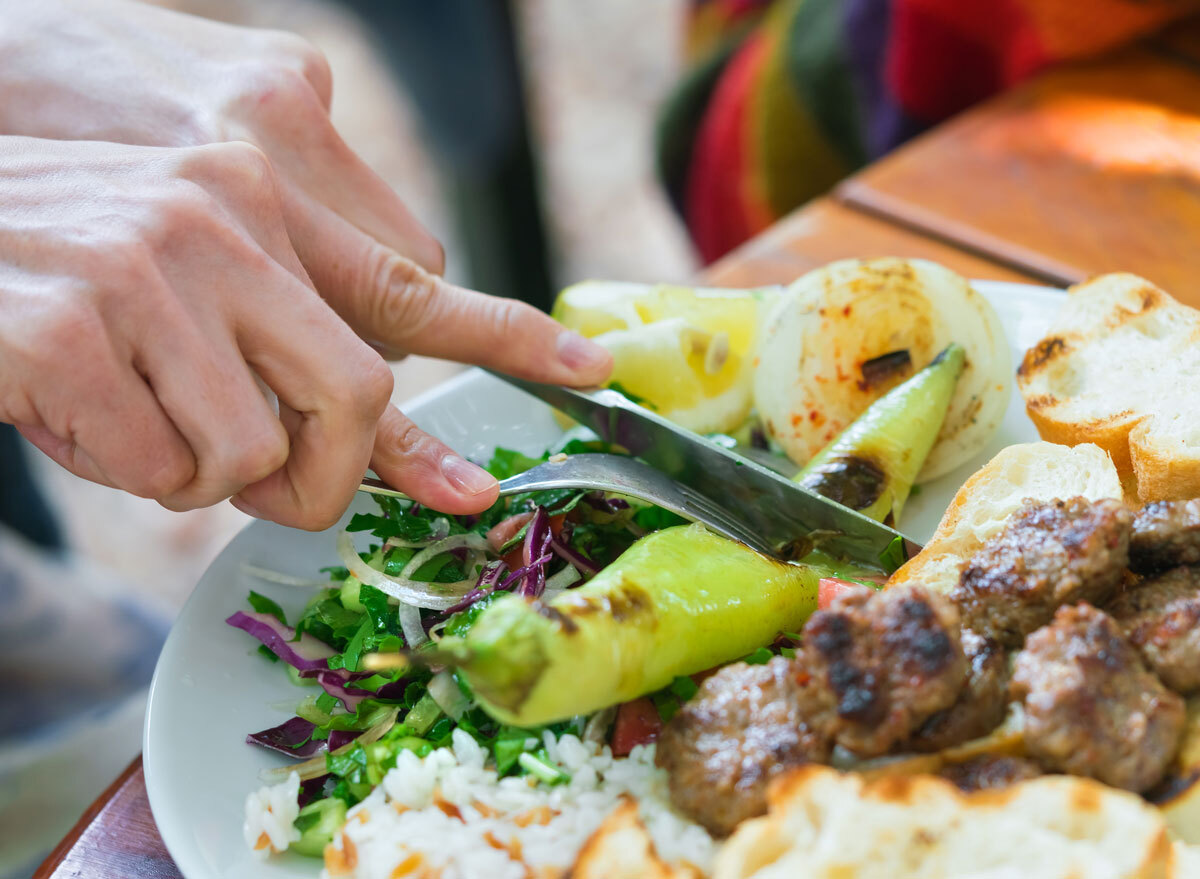 Eating mixed grill off large plate