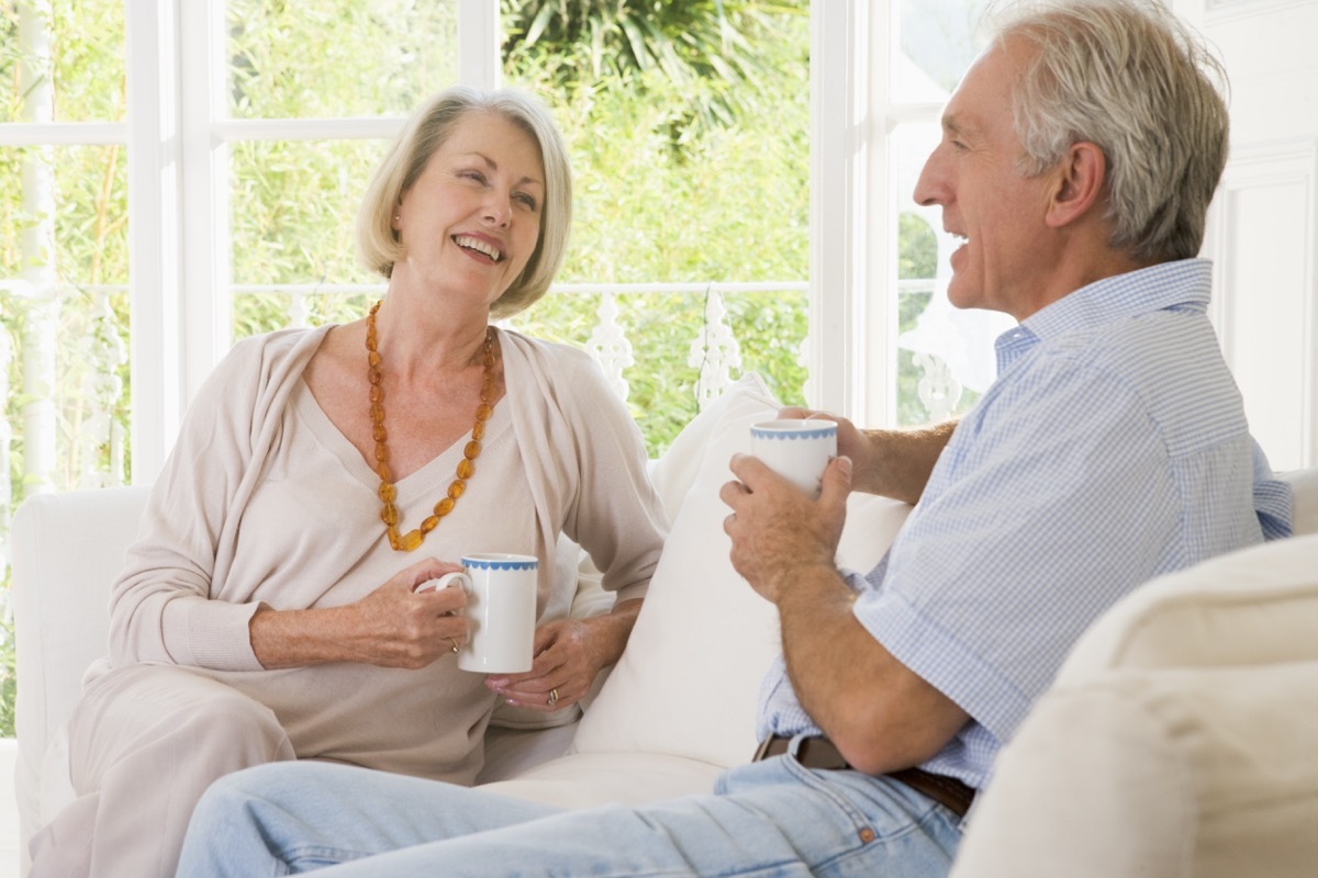 older white couple talking on couch