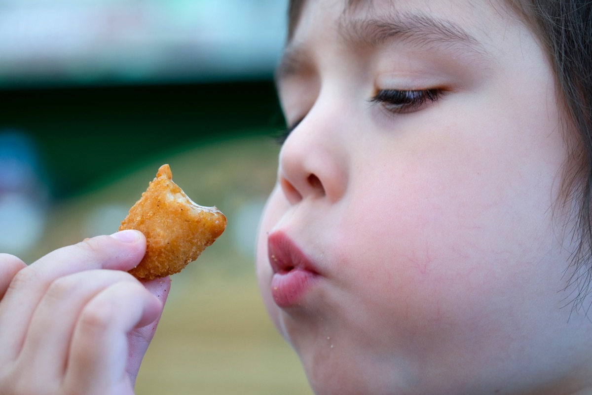 young white boy eating fish finger