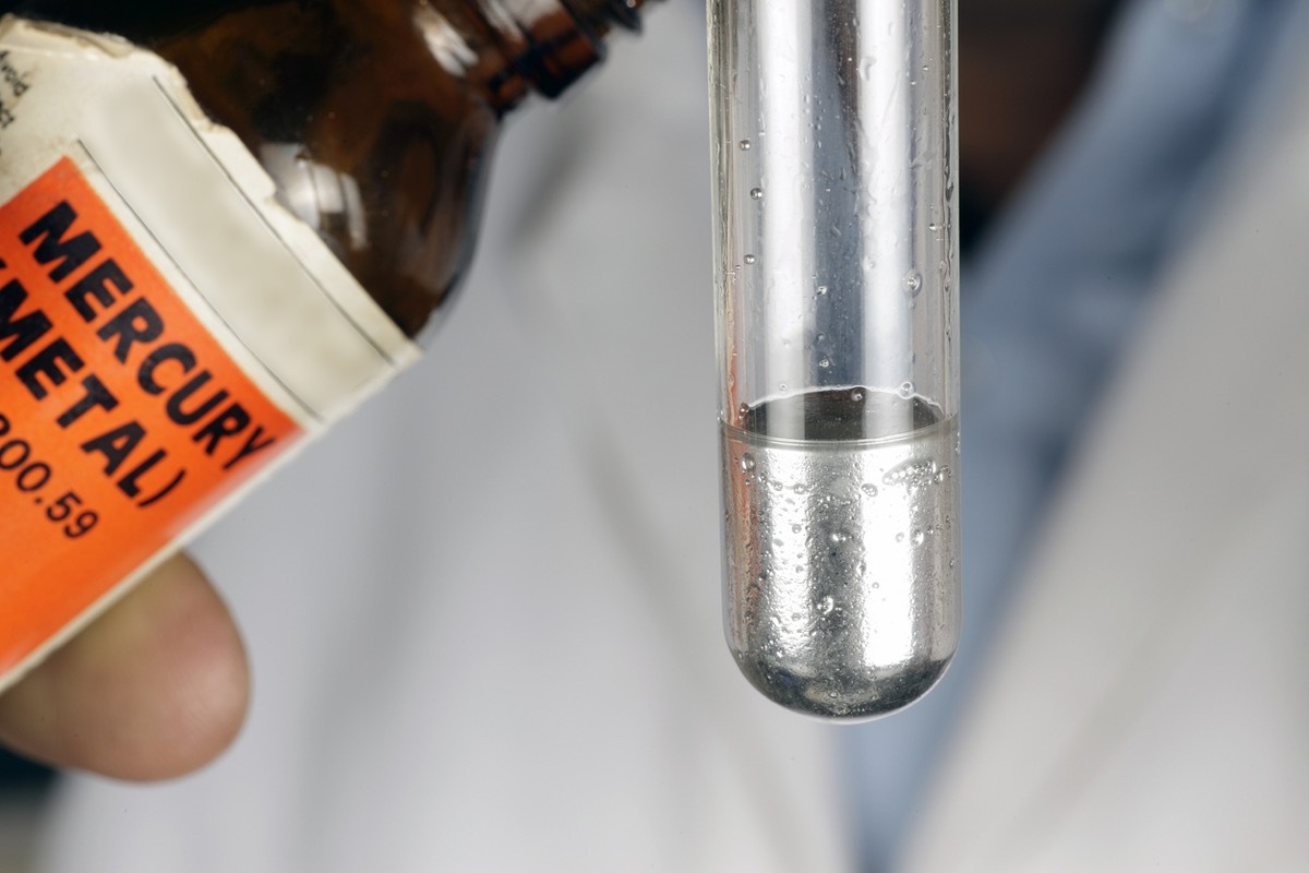 Pouring out mercury from a bottle to a test tube.