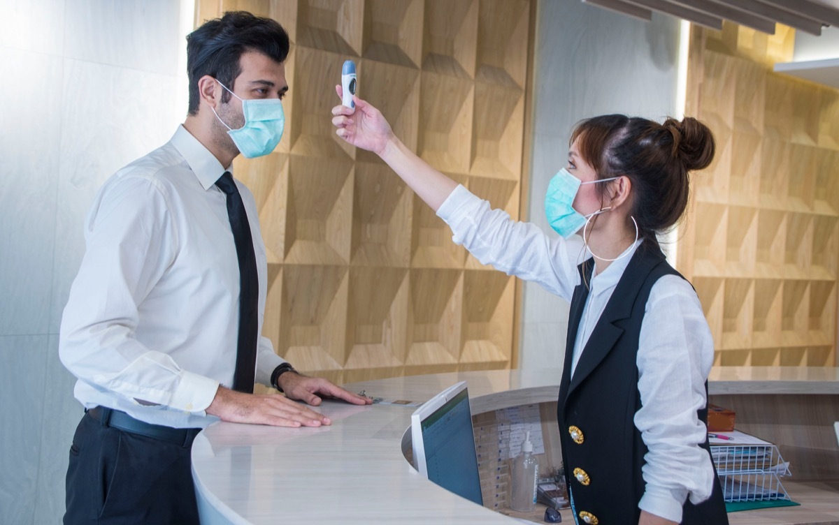 Man getting his temperature checked before entering building during coronavirus outbreak