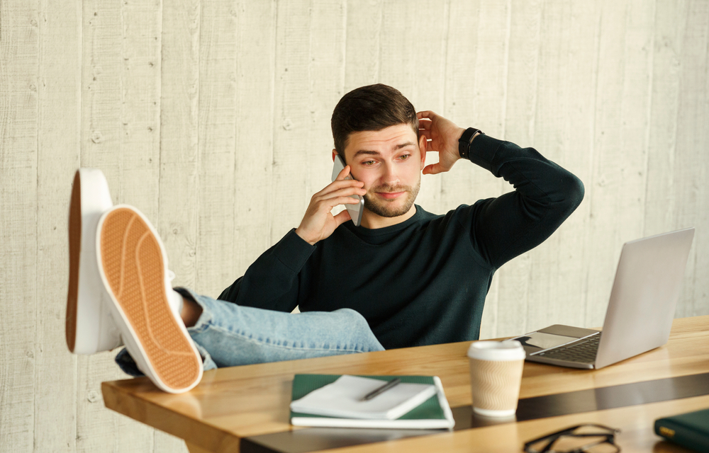 irresponsible man on the phone at his desk