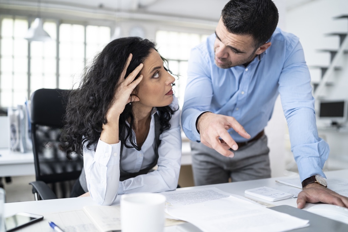 Coworkers sitting at workplace and discussing problems.