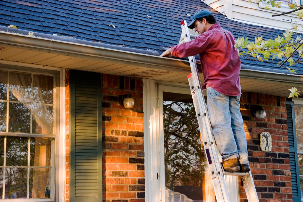 Man Cleaning Out Gutters Boosting Your Home's Curb Appeal