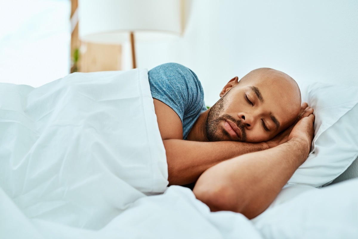 Black man sleeping in his bed