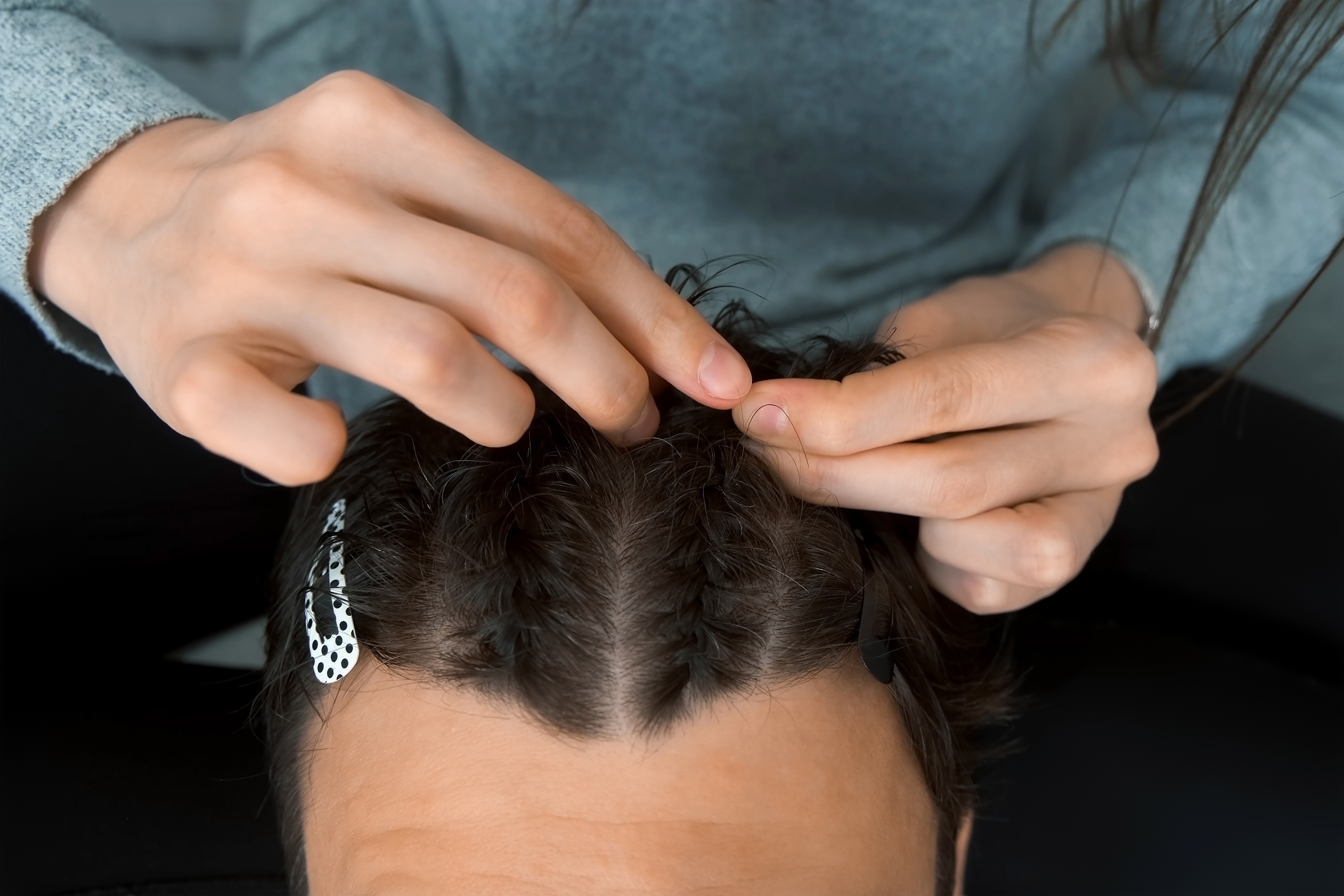 woman doing french braids on friend