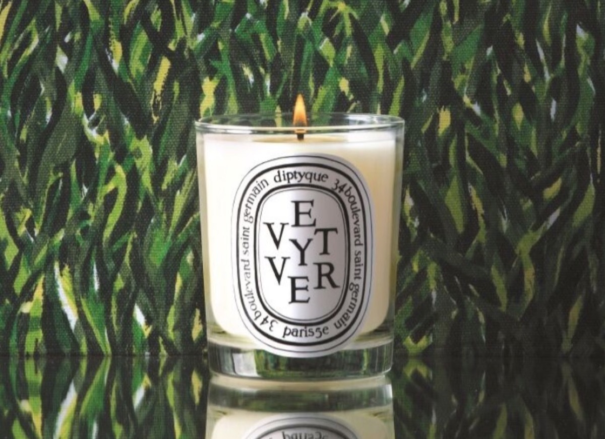 diptyque vetiver candle in front of green background 