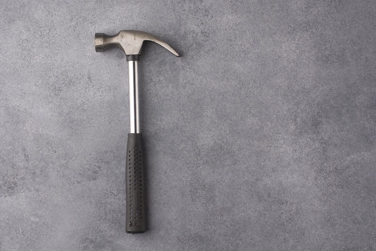 Hammer on a gray background. View from above. Free space for an inscription.