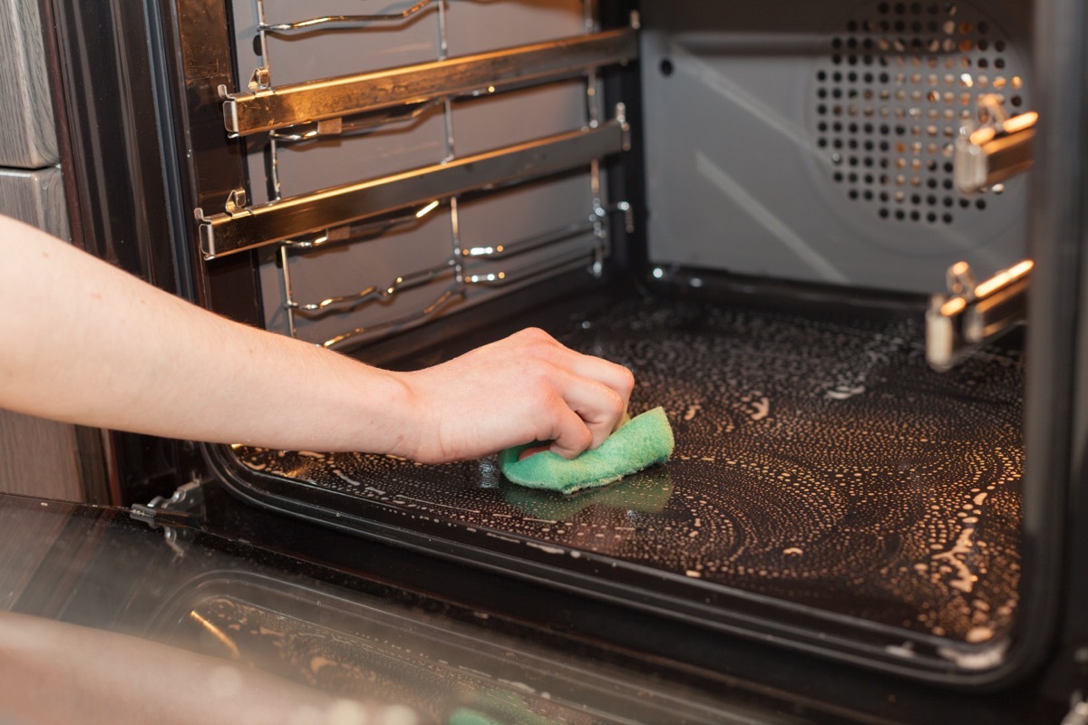 Person Cleaning Oven