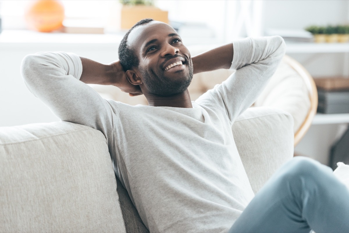 Happy man thinking and smiling on the couch