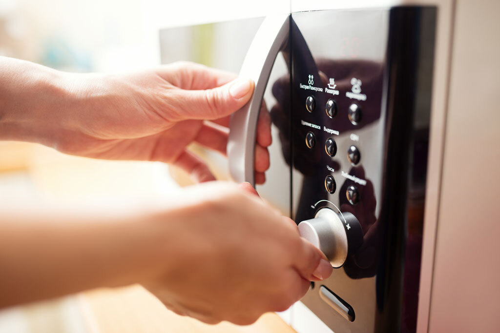 man opening his microwave oven