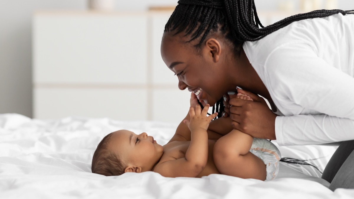 mom playing with her newborn baby