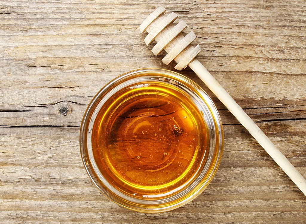 Honey in a bowl with a comb, one of the many cold remedies