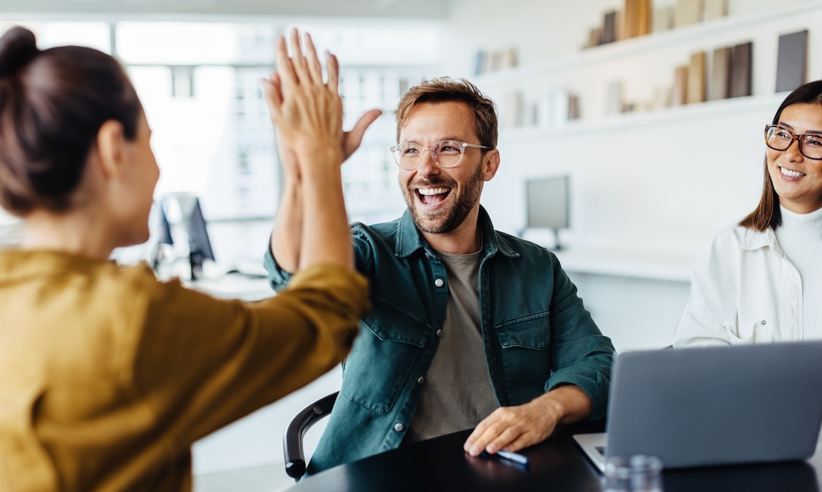 A happy young man high-fiving his female colleague.